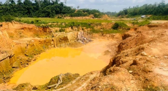 Ghana galamsey satire — polluted mining pit with toxic yellow water showing environmental destruction