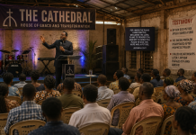 Thieves of the Cathedral: When the Warehouse Became the Cathedral Thieves of the Cathedral Episode 3 – Apostle Dr. B.K. Abotare preaching to the growing congregation inside the transformed warehouse in Adomkrom