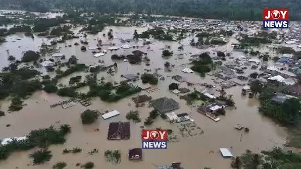 Galamsey and severe flooding in Samreboi, Ghana, showing homes and buildings submerged in muddy floodwaters.